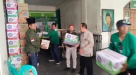 Sejumlah anggota panitia gotong royong menaikkan sejumlah kardus komsumsi ke atas pick up untuk didistribusikan. (foto : istimewa)