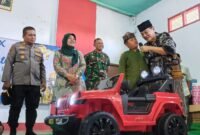 Anak yatim di kecamatan Tirtoyudo mendapat hadiah utama mobil listrik mainan dari Komisaris Utama PT.Anugerah Citra Abadi (ACA), Iwan Kurniawan, Kamis (12/03/2026). (Foto Kim )