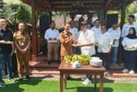 Sekretaris SMSI Malang Raya, Dadang Dwi Tanto (Dudung) memberikan potongan tumpeng kepada Kadis Kominfo Kota Malang, Muhammad Nur Widianto. Foto (Kim/ngalamutas.com)