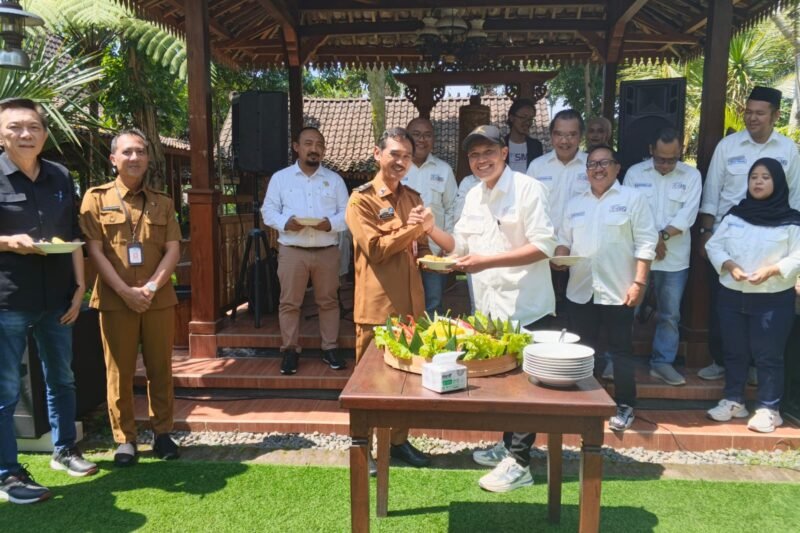 Sekretaris SMSI Malang Raya, Dadang Dwi Tanto (Dudung) memberikan potongan tumpeng kepada Kadis Kominfo Kota Malang, Muhammad Nur Widianto. Foto (Kim/ngalamutas.com)